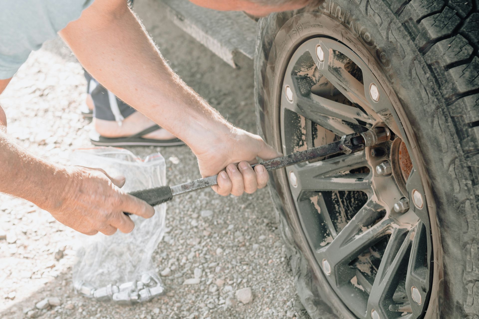 a man working on a tire with a wrench